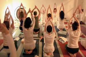 a yoga teacher leading a kundalini yoga class